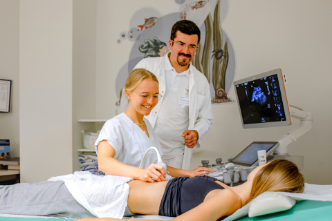 Dr. Alena Gschwind, Ärztin in Weiterbildung in der Kinderklinik des UKJ, gemeinsam mit Dr. Paul-Christian Krüger, Oberarzt in der Sektion Kinderradiologie des Instituts für Diagnostische und Interventionelle Radiologie am UKJ, bei der Ultraschalluntersuchung einer Jugendlichen. Foto: Rodigast/UKJ