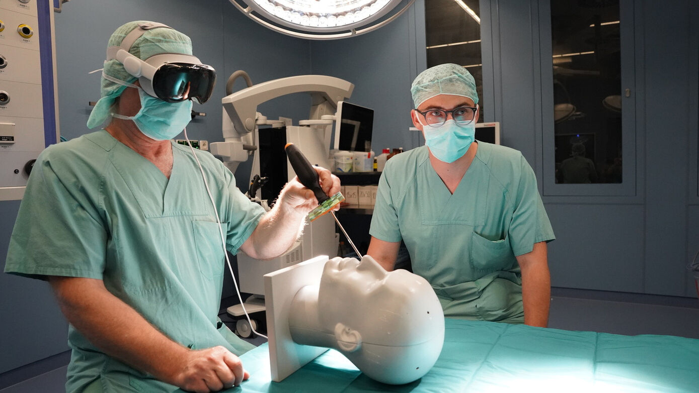 Prof. Dirk Winkler (li.), stellvertretender Direktor der Klinik und Poliklinik für Neurochirurgie, und Conrad Günther, technischer wissenschaftlicher Mitarbeiter, bei der Arbeit mit der Datenbrille „Apple Vision Pro“ im Labor. Das Modell, dass es in Deutschland bisher noch gar nicht gibt, durften sie für weitere Entwicklungsarbeit exklusiv mit nach Leipzig nehmen
Foto: PD Dr. Ronny Grunert