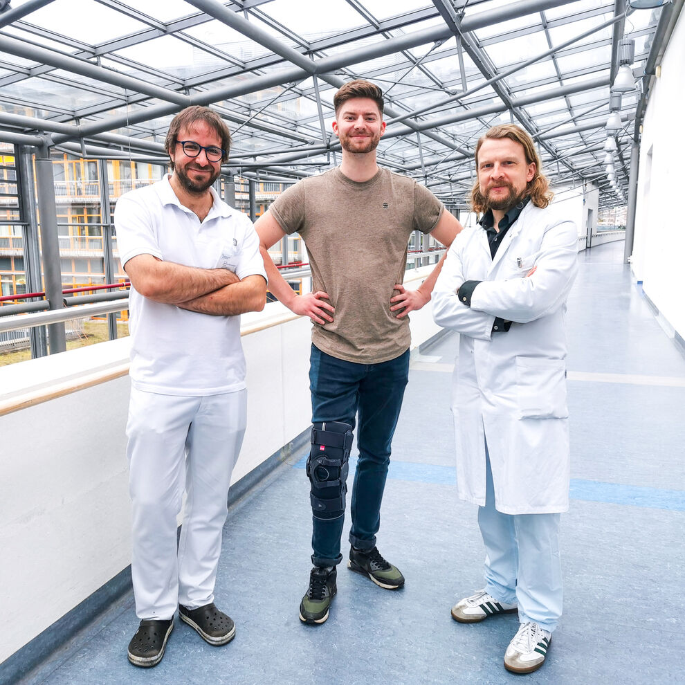Im Team den Knochenkrebs er folgreich bekämpft :
Dr. Wolfram Weschenfelder (links) und Dr. Christian Spiegel (rechts), Chirurgen in der Klinik für Unfall-, Hand- und Wiederherstellungschirurgie und Orthopädie und Leiter des SarkomCentrums, mit ihrem Patienten Daniel Grienberger. Foto: UKJ
